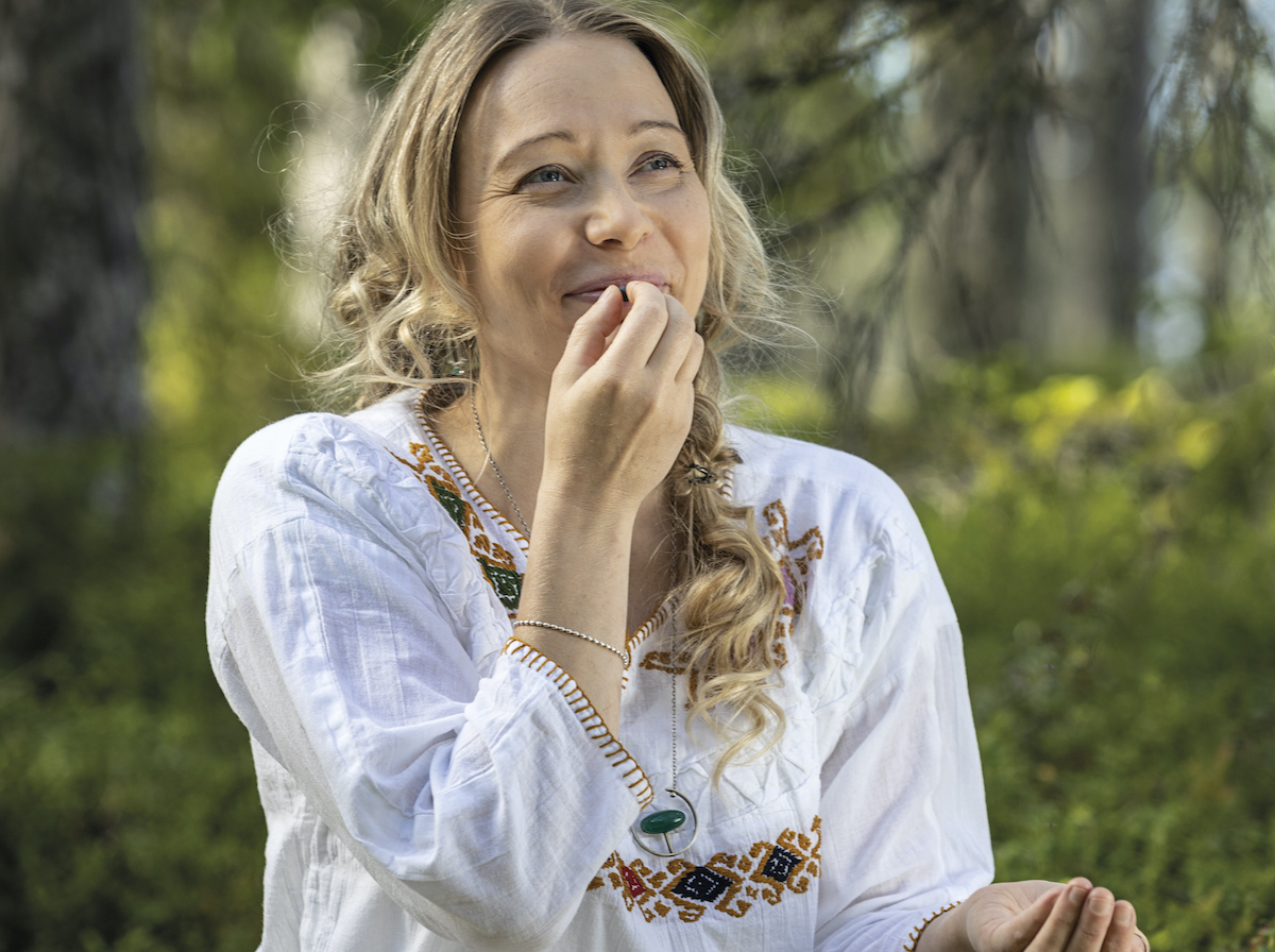 Nainen maistaa villiyrttejä metsässä Lentiirassa. 
