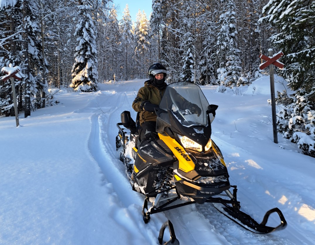 Winter forest landscape with snowmobile on front.